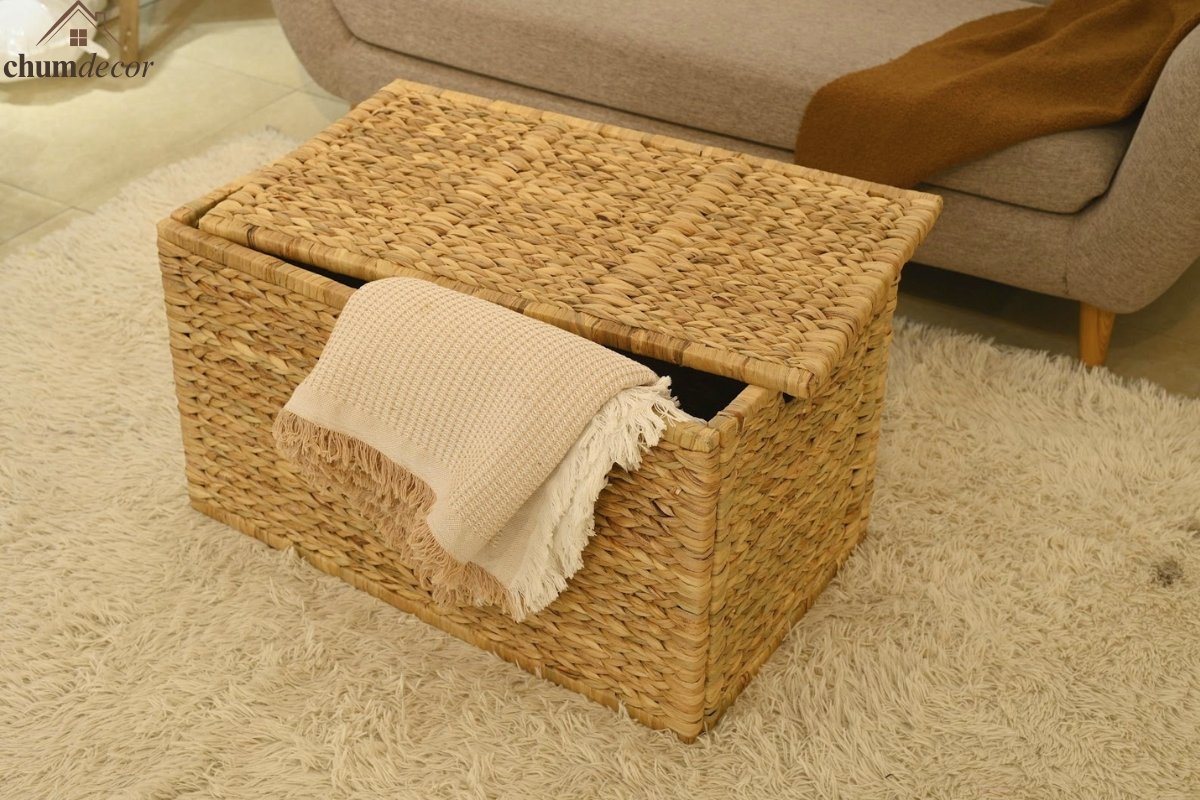 Boho Reading Nook Featuring a Wicker Storage Trunk Wicker trunk placed beside a soft beige couch, styled with a cream boho throw for a reading nook feel.