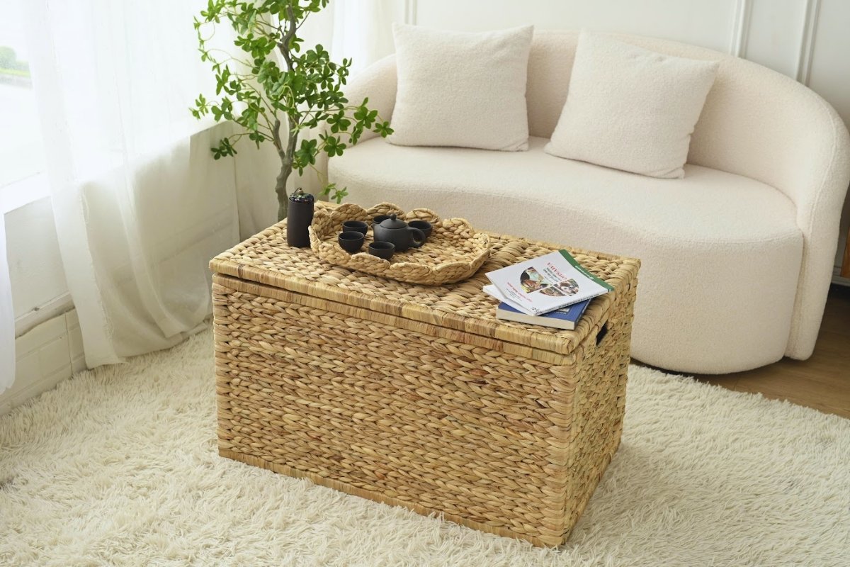 Wicker storage trunk coffee table decorated with stacked books and a soft boho throw.