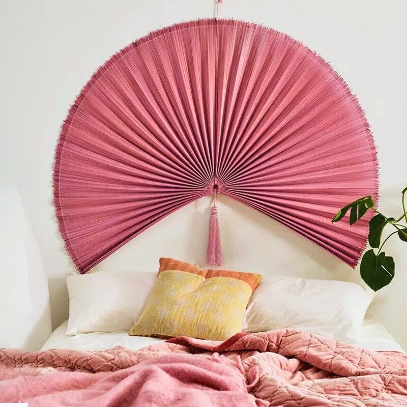 Pink folding fan wall decor as headboard accent Pink folding fan wall decor as headboard accent