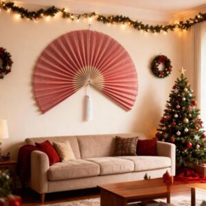Pink wall fan made from handmade bamboo styled as decorative wall art above a sofa in a warm holiday living room
