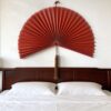 Large bamboo wall fan decor above bed in modern bedroom interior