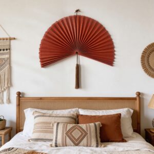 Large bamboo wall fan decor above rattan bed in boho bedroom