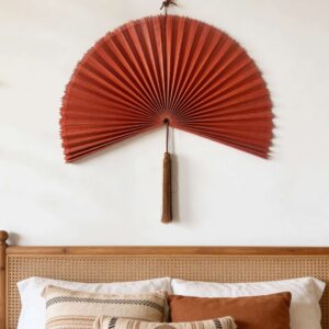 Large bamboo wall fan decor above rattan bed in modern bedroom